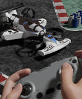 Hands operating 2 In 1 Flying Car Stunt Drone For Outdoors And Indoors With Dual Land And Air Modes RC Quadcopter Toy on race track.
