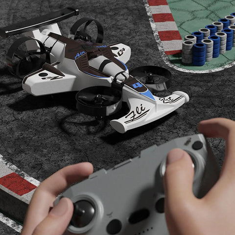 Hands operating 2 In 1 Flying Car Stunt Drone For Outdoors And Indoors With Dual Land And Air Modes RC Quadcopter Toy on race track.