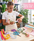 Woman using Four Piece Flower Scissors Set With Stainless Steel Blades And Comfort Grip Handles for flower arranging indoors.