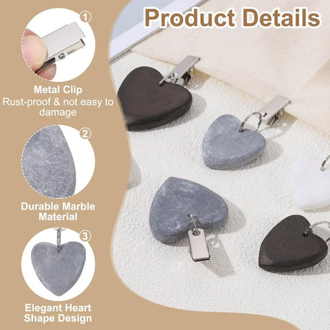 Close-up of marble heart tablecloth weights with clips, showcasing durable gray design and metal fasteners for outdoor decor.