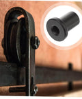Close-up of Five Piece Barn Door Track Spacers And Connectors Kit, showing black steel spacer on sliding door hardware.