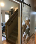 Space Saving Rustic Wood Mountains Sliding Barn Door For Home with mountain design, used as room divider, view showing staircase entry.