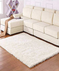 Modern living room with white sectional sofa, fluffy white rug on wooden floor, geometric shelf