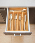 Premium Bamboo Kitchen Drawer Organizer Nine Inch Silverware Tray with cutlery arranged in a bamboo caddy.
