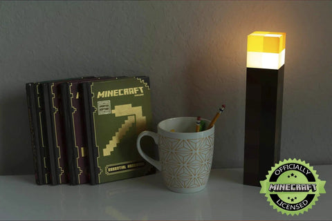 Brownstone Torch Lamp 11.5 Inch LED Night Light With USB Charging Port next to books and cup on desk setup.