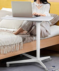 Slick Mobile Laptop Desk With Adjustable Height And No Sweat Rolling Casters Nifty Bedside Workstation in use beside a bed.