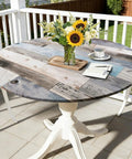 Round Fitted Tablecloth With Elastic Edge For Indoor And Outdoor Use Waterproof Wipeable Table Cover For 36 To 44 Inch Round Tables Farmhouse Style No Fuss Cleanup Dinner Picnic Patio Decor on wooden texture table outdoors with sunflowers in vase.