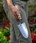 Person holding 13 Inch Stainless Steel Garden Trowel With Oak Handle And Leather Wrist Strap Built To Last For Digging And Planting
