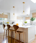 Gold Pendant Lights For Kitchen Island Three-Pack With Mini Bell Glass Shades hanging above a white countertop
