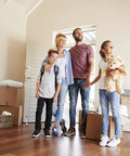 Family standing in a new home surrounded by moving boxes.