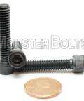 1/4-20 X 1-1/4 Socket Head Cap Screws High Strength A574 Alloy Steel Black Oxide, showing three bolts with a penny for scale.