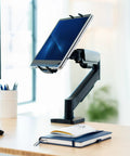 Level Up Your Workspace With This Height Adjustable Counterbalance Desk Mount For Tablets And 15 6 Inch Two In One Laptops Slick Spring Loaded Arm Rock Solid Grip Smooth Glide Finish Black holding a tablet on a desk.