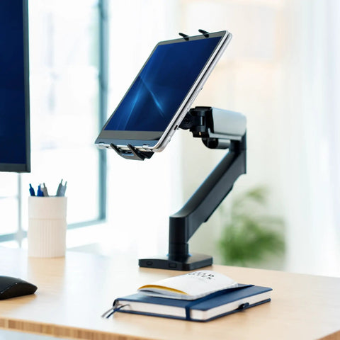 Level Up Your Workspace With This Height Adjustable Counterbalance Desk Mount For Tablets And 15 6 Inch Two In One Laptops Slick Spring Loaded Arm Rock Solid Grip Smooth Glide Finish Black holding a tablet on a desk.