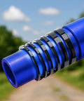 Blue aluminum bicycle headset spacers in various sizes for 1 1/8 inch stems, shown outdoors on a background of trees and sky.