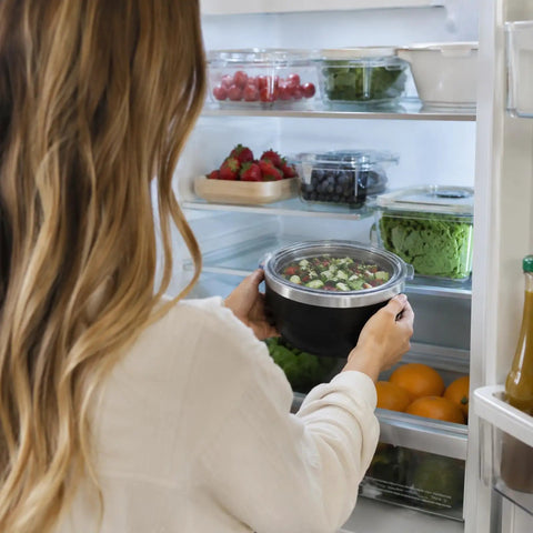 Person placing Hella Solid 32 Oz Double Wall Vacuum Insulated Stainless Steel Bowl With Tight Seal Silicone Lid in a fridge.