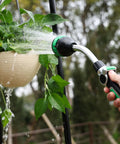 Heavy Duty Metal 2-In-1 Garden Hose Wand With 9 Spray Patterns in use watering hanging plants outdoors