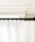 Top Tier Premium Metal Curtain Rings With Quiet Smooth Removable Nylon Inserts Pinhooks And Clips Included One Point Five Inch Inside Diameter 18 Rings For Two Standard Curtains Ultra Sleek Tuxedo Black installed on a curtain rod
