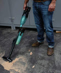 Man using Cyclonic Vacuum Attachment For 18v And 12v Cordless Handheld Tools on dusty workshop floor.