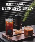 Manual Espresso Maker For On The Go Portable Coffee Machine With 2 In 1 Bottomless Portafilter next to iced coffee on tray