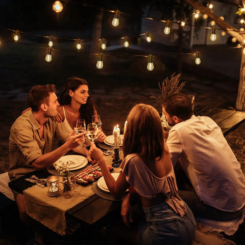 Group enjoying dinner under Outdoor LED String Lights 54 Ft Weatherproof IP65 Shatterproof 20 Sockets Patio Lights at night