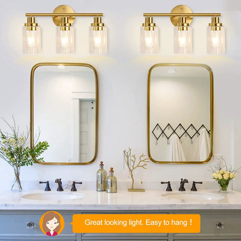 Double vanity with Brushed Brass 3 Light Vanity Fixture With Clear Glass Shades Wall Sconce Vibe illuminating bathroom mirrors.
