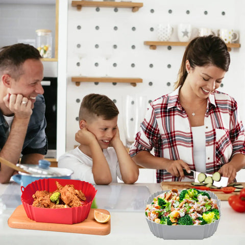 Family in kitchen with red silicone air fryer liner holding food; Square Red Silicone Air Fryer Liners 8 Inch Fits 4 To 6 Qt Reusable Nonstick Heat Resistant Up To 464F Dishwasher Safe Easy Cleanup Air Fryer Accessories visible on countertop.