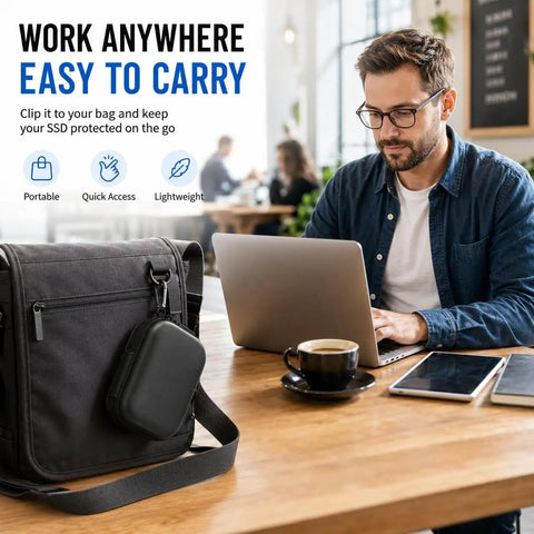 Man working at café table with laptop next to Carrying Case For Crucial X10 X9 Pro Portable SSD, black hard storage bag attached to backpack.