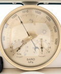 Close-up of All In One Indoor Outdoor Barometer Thermometer Hygrometer Weather Station showing air pressure and temperature gauge.