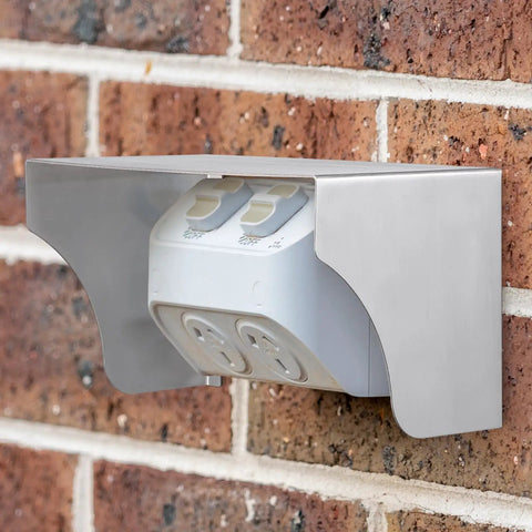 Tough As Nails Stainless Steel Doorbell Cover Plus Weatherproof Electrical Outlet Protector Shield Box For EV Charging Stations mounted on a brick wall.
