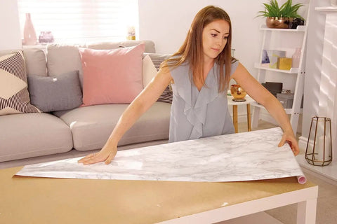 Woman using Grey Marble Peel And Stick Self-Adhesive Film Roll 17 Inch By 78 Inch for table DIY makeover in living room.