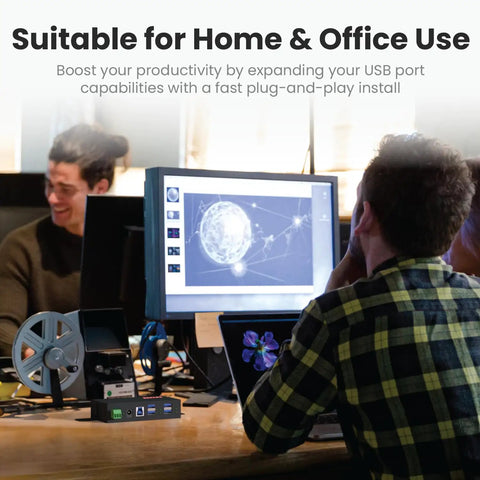 Built Like A Tank 4 Port USB 3.2 Gen 1 Industrial Metal Hub on a desk for home and office use, surrounded by computer equipment.