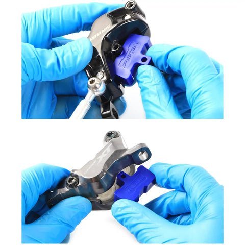 Inserting a blue brake bleed block in a universal caliper from the 8 Piece Bike Hydraulic Disc Brake Bleed Blocks And Spacers Kit.