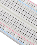Close-up of Compact Mini Breadboard With 400 Tie Points And Dual Power Lanes For Arduino Projects Measuring 5.5 By 8.2 By 0.85 Cm