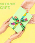 Hands exchanging a green gift box with colorful ribbon, featuring a bracelet from the Colorful Fruit Polymer Clay Beads Bracelet Making Kit.