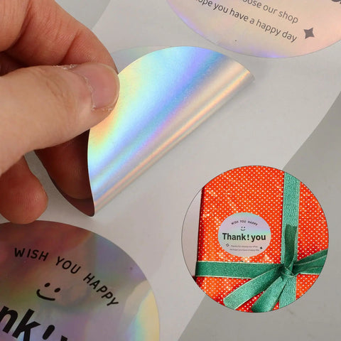Thank You Stickers For Packaging And Gift Wrapping, shiny label being peeled and applied to a gift box with ribbon