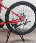 Garage Ready Vertical Triangle Bike Stand For Indoor Parking, metal and black, holding a bike by the rear wheel in a garage.