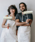 Two people holding 24 Pack Bulk Paint Roller Covers In Microfiber For Walls And Ceilings Nine By One Half Inch Polyester Naps