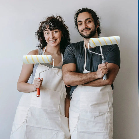 Two people holding 24 Pack Bulk Paint Roller Covers In Microfiber For Walls And Ceilings Nine By One Half Inch Polyester Naps