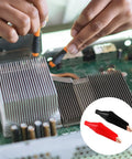 Person using Insulated Copper Gator Clips 24 Pack for Electrical Testing Red and Black Crocodile Clamps on circuit board.