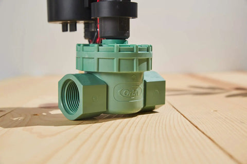 Battery Powered Outdoor Sprinkler Timer For Yard With Four Valve Control on wood surface, 1 Inch FPT Jar Top Valve visible