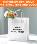 White kraft paper bag with handles, showcasing "Your Printed Logo Here," part of 500 Pack Custom Printed Kraft Paper Bags For Small Biz With Logo Brown White Shopping Bags With Handle Personalized Gift Bags For Branding In Retail Suitable For Promotions Goodie Bags, flowers inside