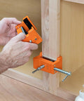 Person using Badass Cabinet Clamps 2 Pack For Real Woodworking Projects With Flip Side Pilot Drill Guide Heavy Duty Aluminum Build 440 Pound Holding Power Fits One Point Five To Two Inch Door Stiles on wooden panel.