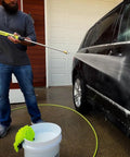 Person using Pressure Washer Hose With M22 Fittings, 1/4 In By 25 Ft, ZillaGreen Flexible Hybrid Polymer on car.