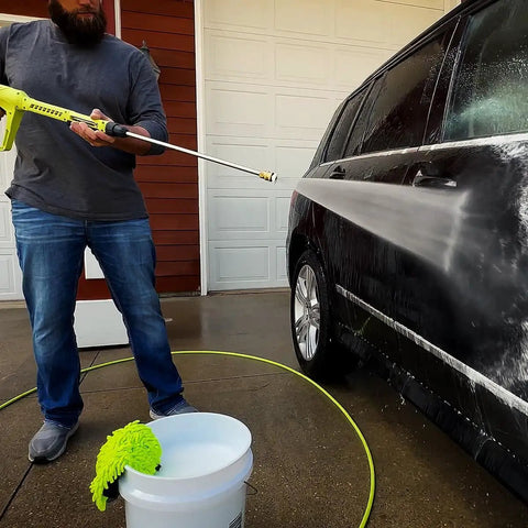 Person using Pressure Washer Hose With M22 Fittings, 1/4 In By 25 Ft, ZillaGreen Flexible Hybrid Polymer on car.