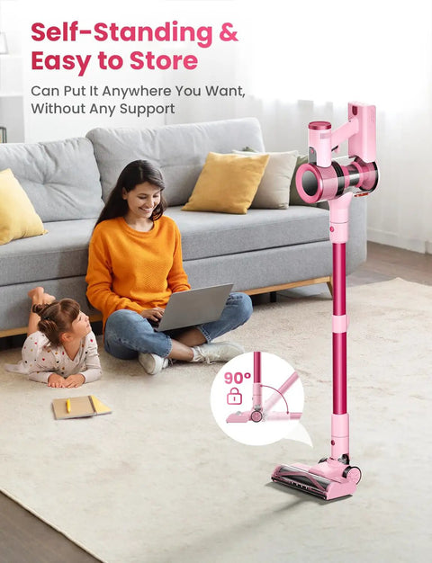 Cordless Stick Vacuum Cleaner With 50KPa Brushless Motor in pink self-standing next to a sofa and smiling woman on laptop