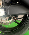Close-up of Orange Swingarm Spools Sliders And Rear Stand Screws Kit for KTM Adventure and Duke motorcycles installed on swingarm.