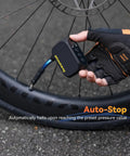 Cyclist using On-The-Go Mini Bike Pump With Gauge to inflate tire, showing Auto Stop feature and real-time pressure display.