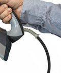Person holding an iron with the Heavy Duty High Temperature Steam Hose for Steam Irons and High Pressure Ironing attached