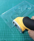 Heavy Duty Replacement Blades For Worx ZipSnip Electric Scissors cutting through clear plastic sheet on green grid cutting mat.