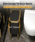 Slim black trash can with lid and gold edge in bathroom next to toilet, space-saving design, modern narrow trash bin on legs